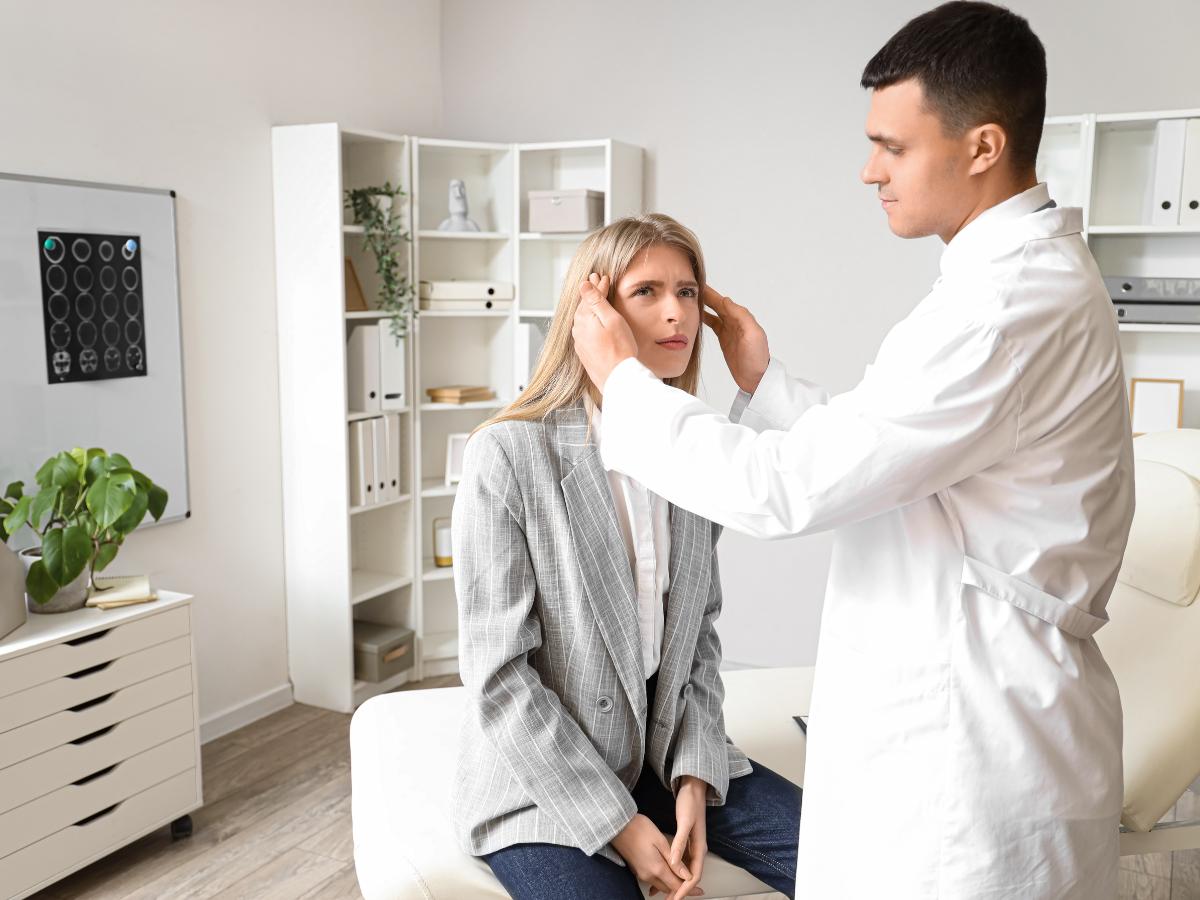 Medical professional discussing nerve compression and its link to muscle spasms during a patient examination