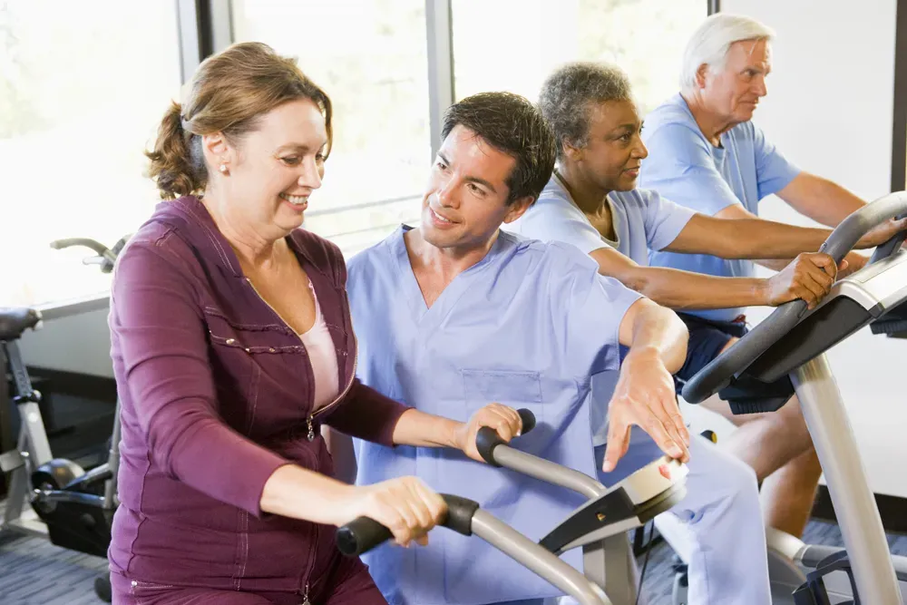 Physical therapist performing manual therapy on a patient to relieve back pain in a bright physical therapy room.